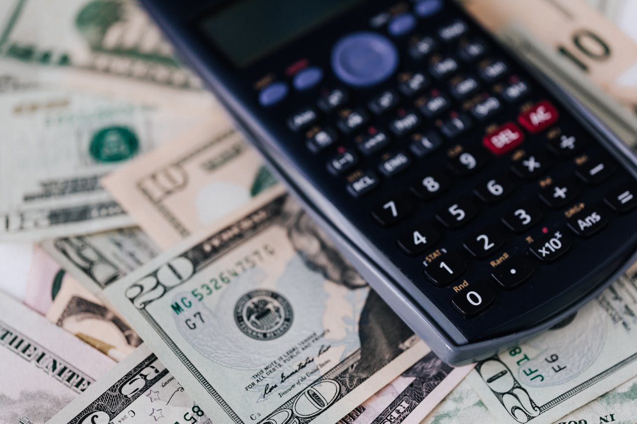 Macro shot of a calculator on US dollar bills, symbolizing finance and budgeting.